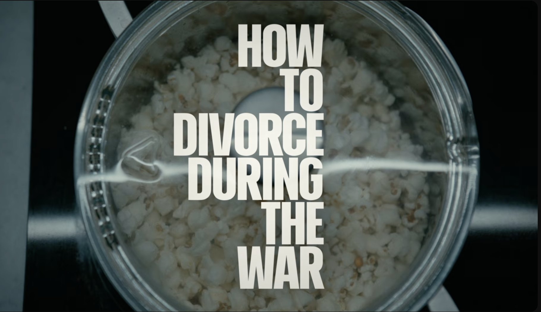 Filmo titrų kadras: užrašas „How to Divorce During the War“ ant spragėsių indo